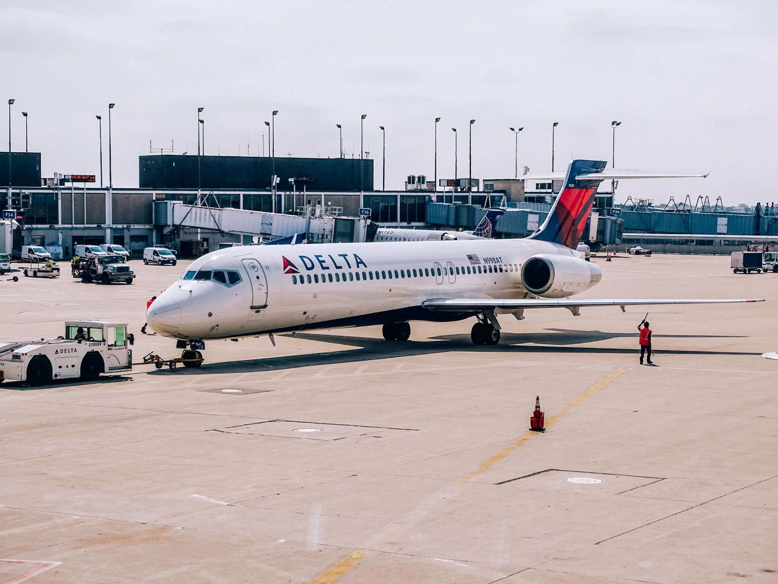 A delta airplane sitting on the tarmac at an airport