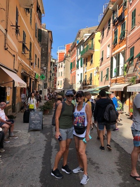 Two women standing in a town in Cinque Terre, Italy on a girls trip