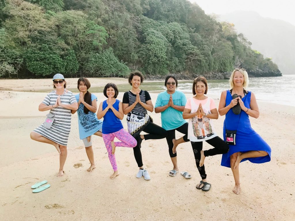 Women on Thai Beach in yoga pose