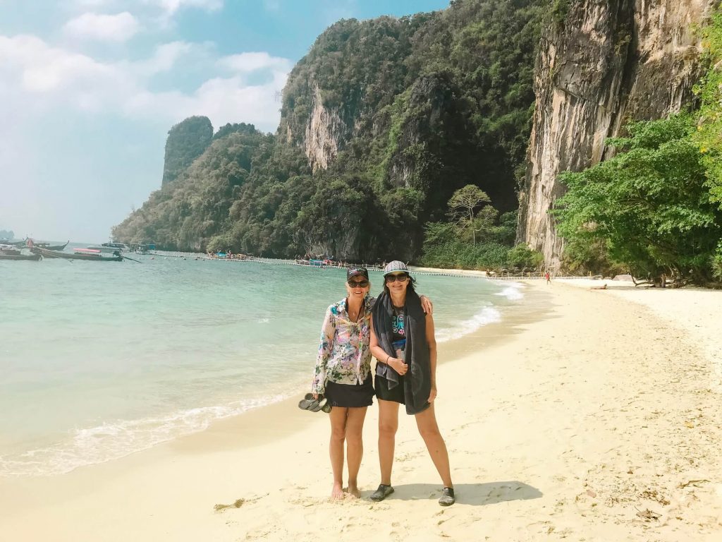 Two women standing on beach in Thailand