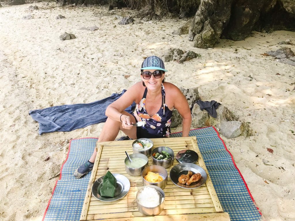 Woman eating Thai food on the beach