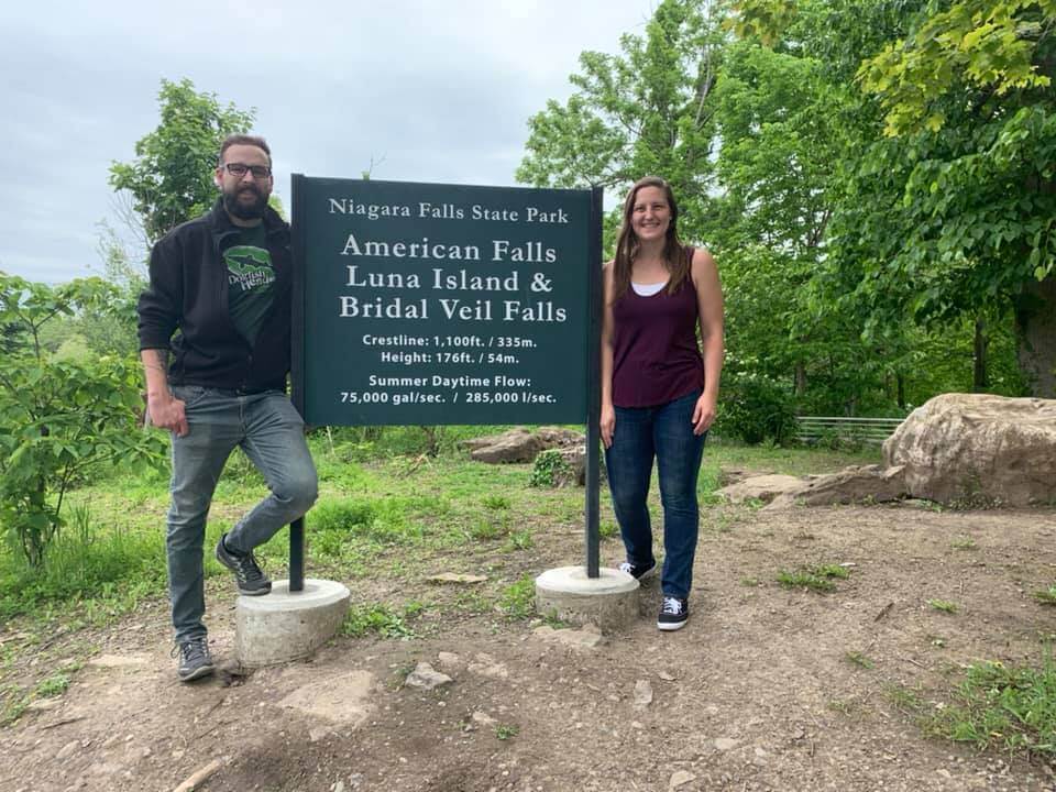 Man and Girl standing by Niagara Fall sign
