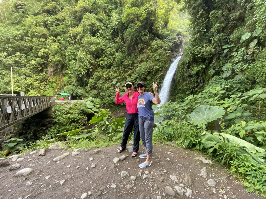 Two women standing in front of waterfall