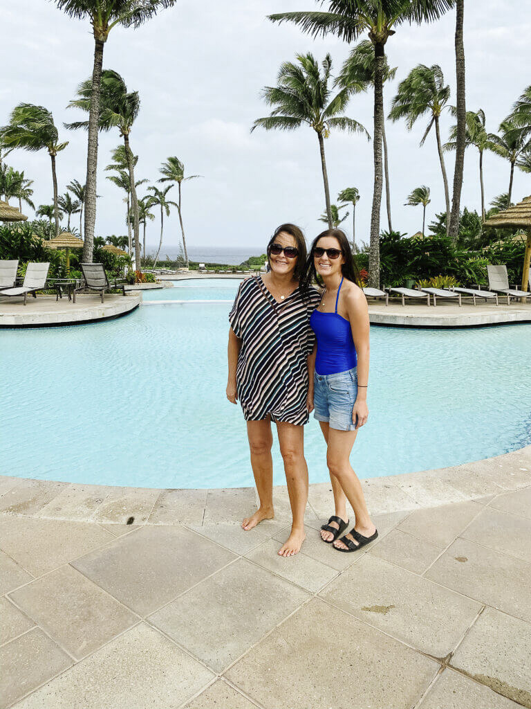 Two women standing in front of swimming pool