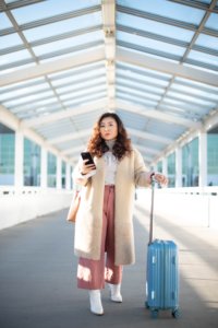Woman in airport with blue luggage