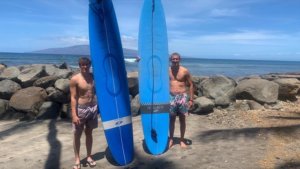 two boys holding blue surfboards
