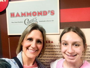 Woman and child standing in front of Hammond's Candy sign