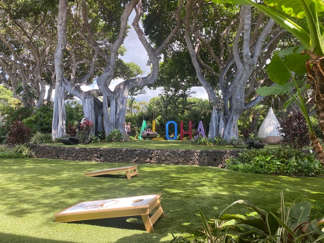 Outside area with ALOHA signage and corn hole game