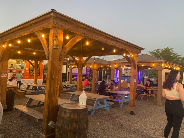 Food trucks around wood gazebo with lights