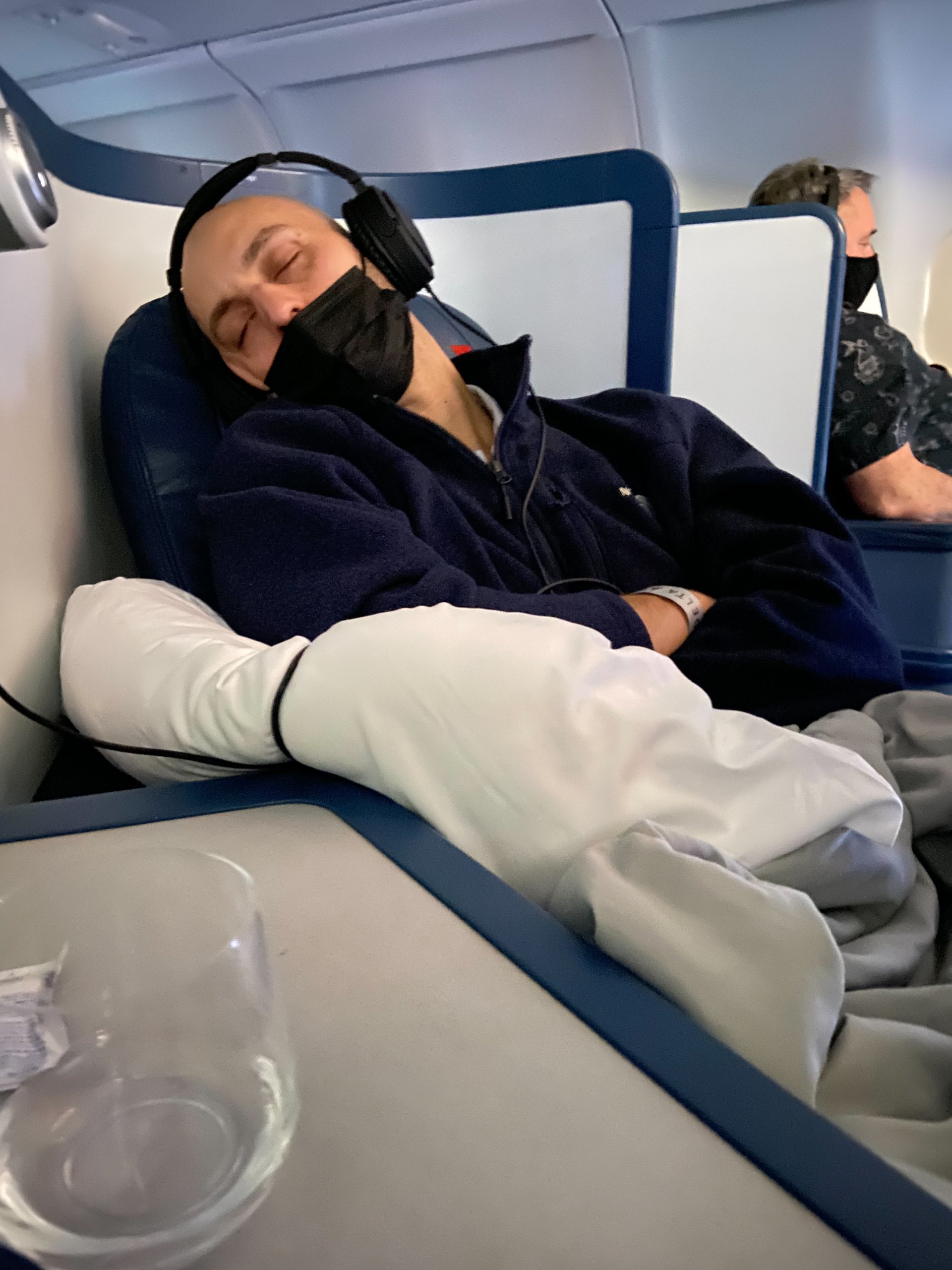 Man sleeping in business class seat on airplane.