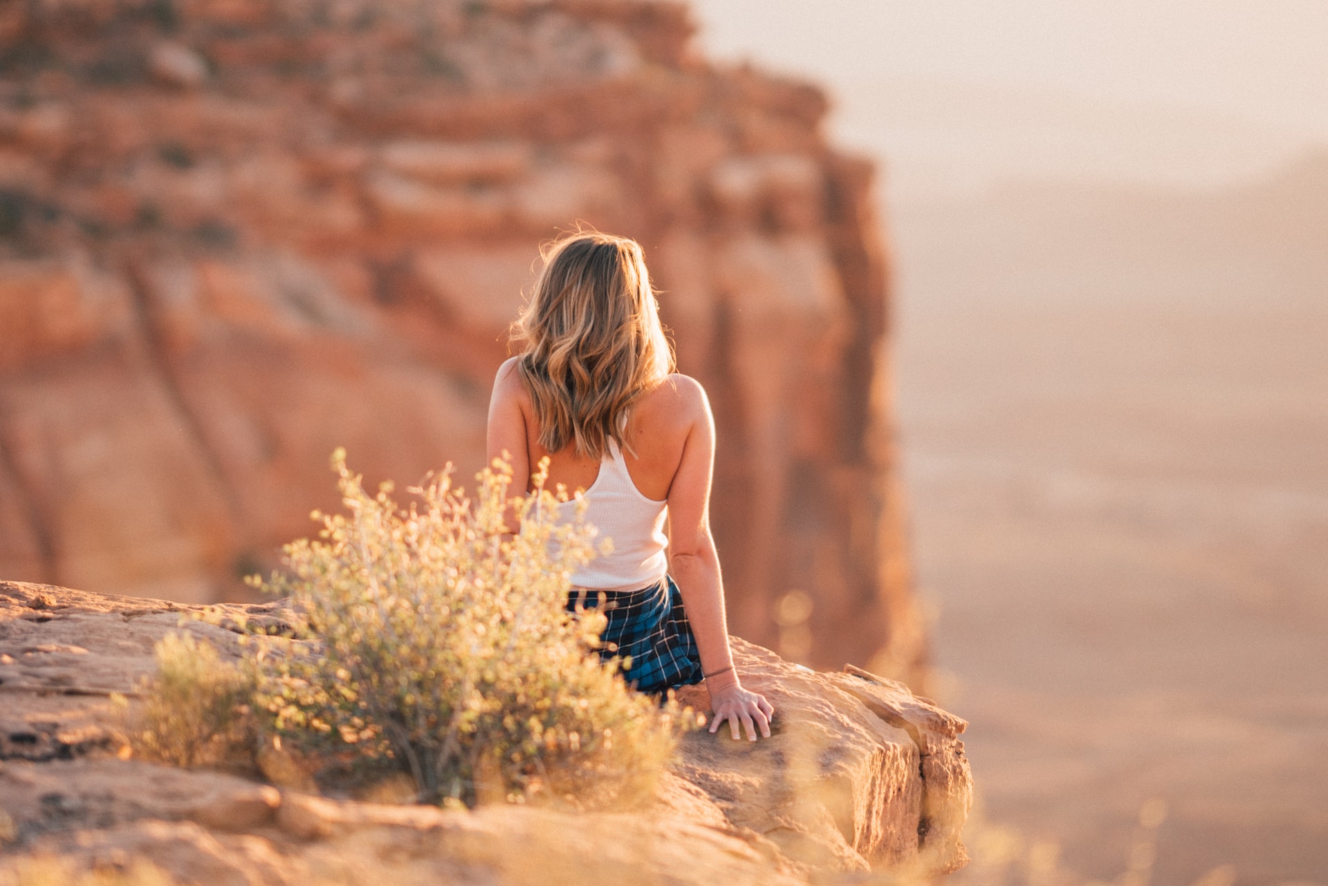 Woman sitting on ledge of red rocks