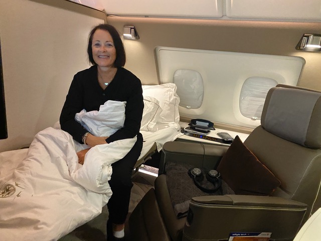 Woman in black pajamas in bed on airline.