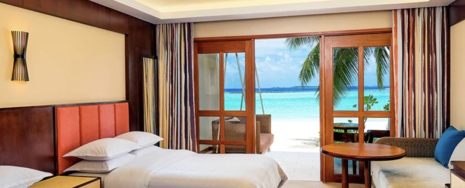 Hotel room with vies of white sand and turquoise water
