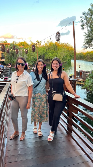 three woman standing on bridge