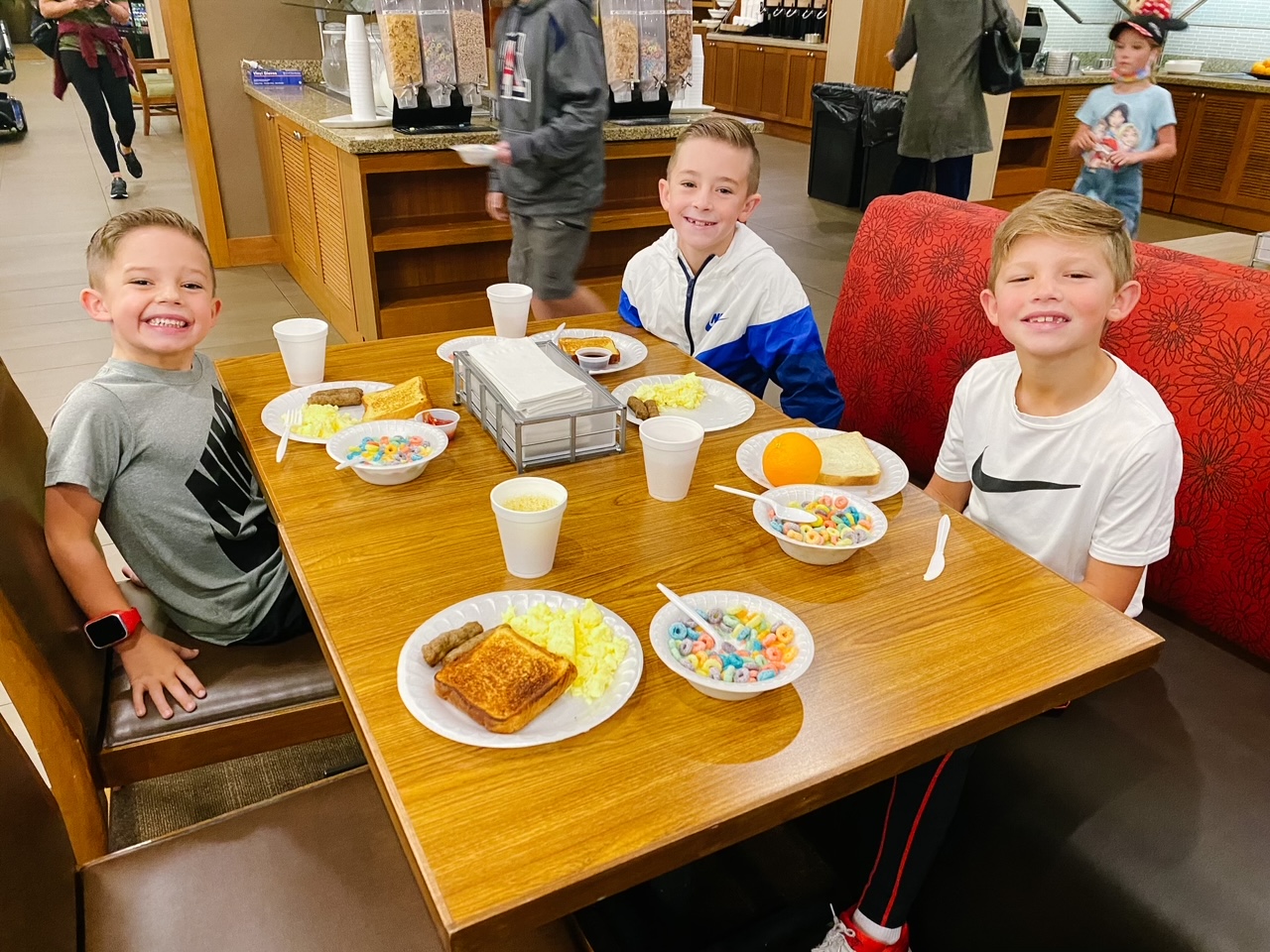 Three boys at table with breakfast foods