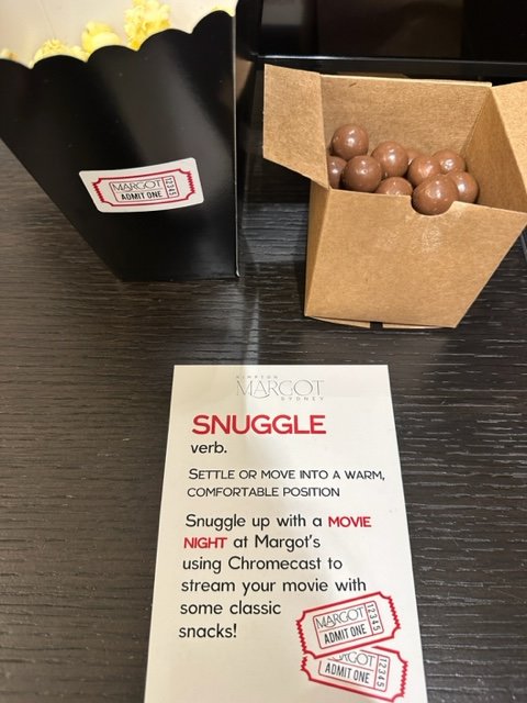 Small popcorn container, candy and note about the word snuggle.