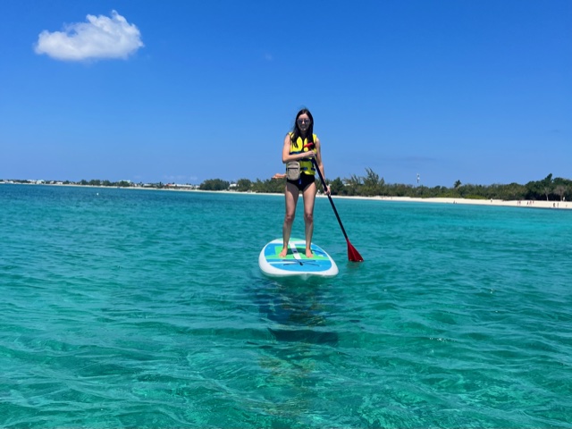 Girl paddle boarding on turquoise water