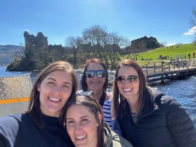 Four women with castle in background