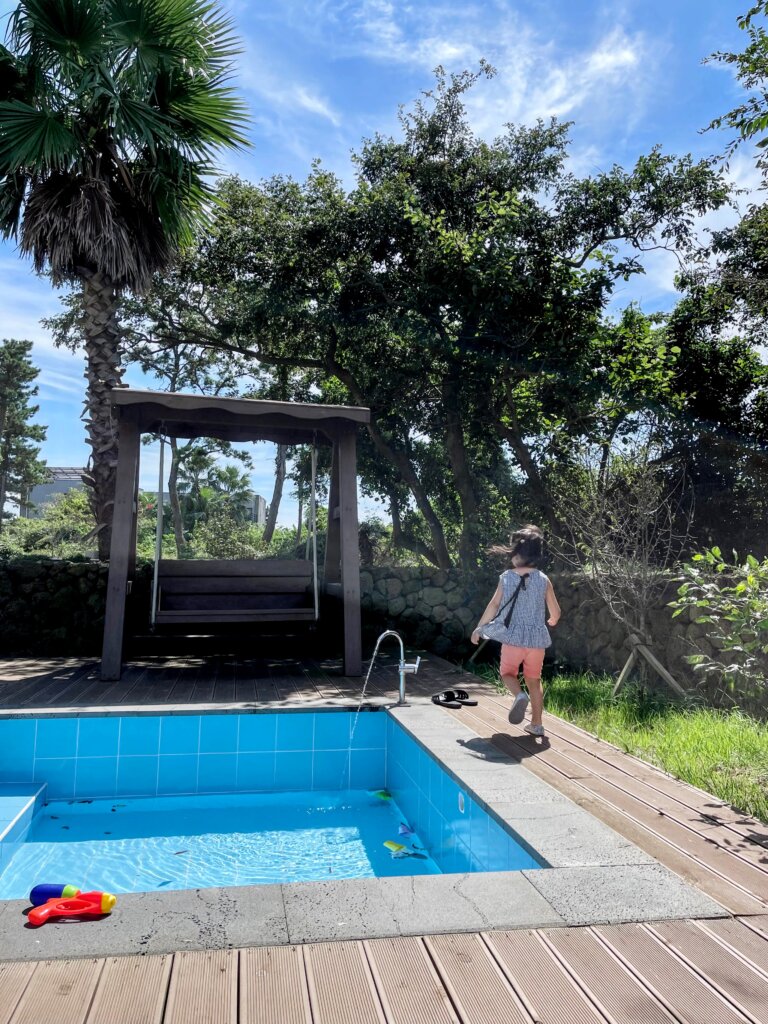 Young girl standing near small pool