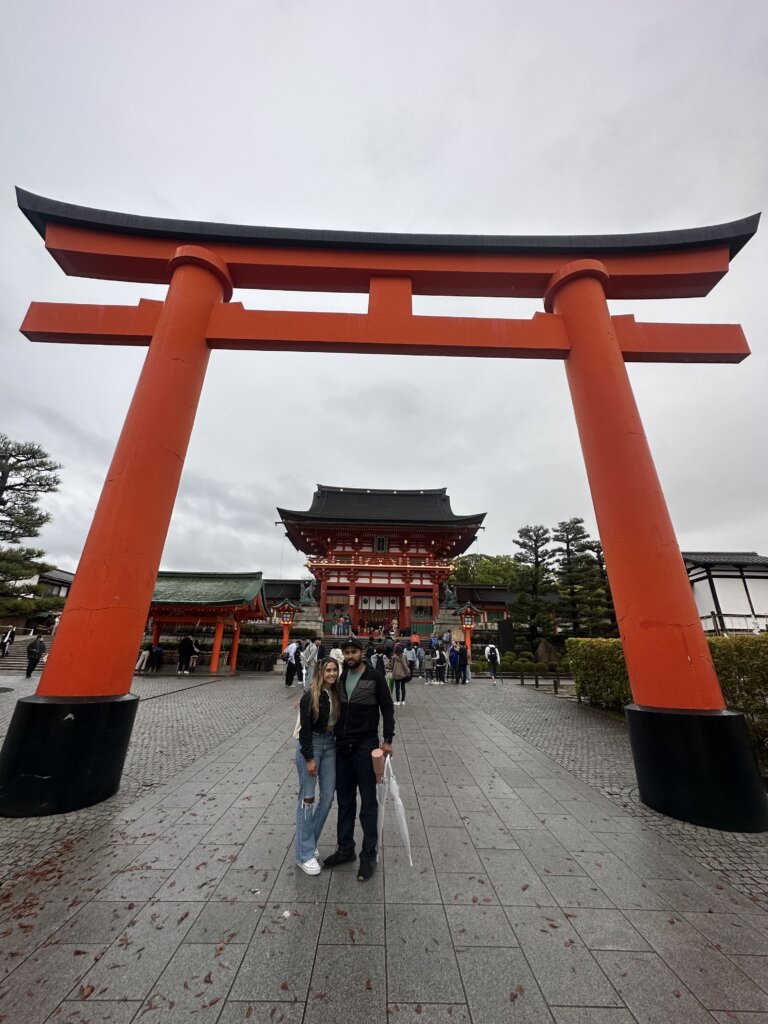 Couple standing at entrance to Japanese shrine.