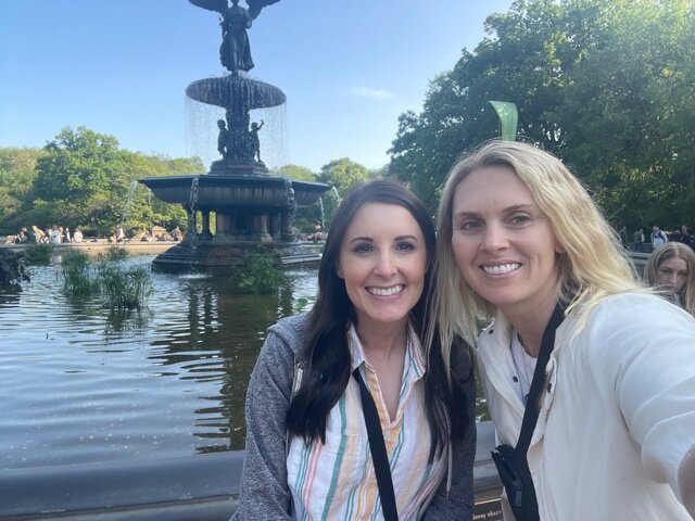 Two woman in front of fountain in park