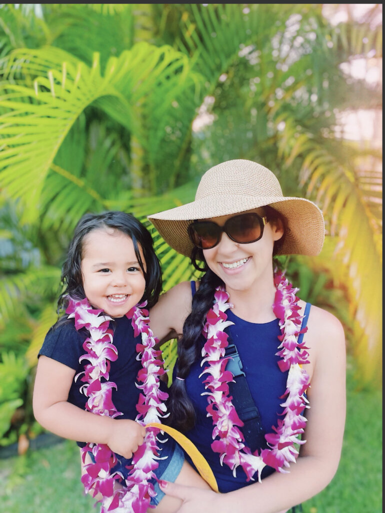 Woman and child wearing flower leis.